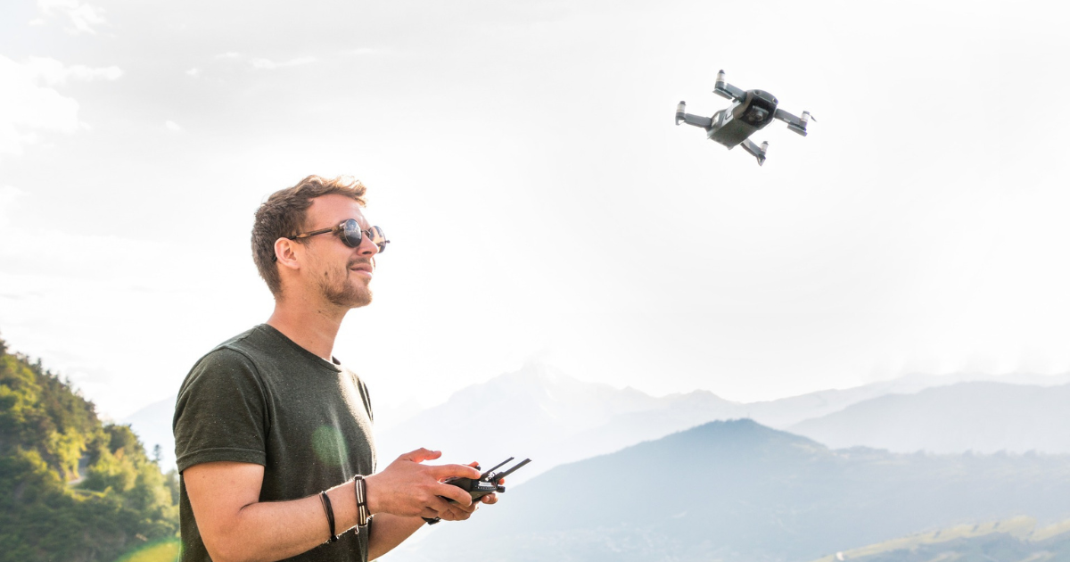 Homem controlando drone com vento