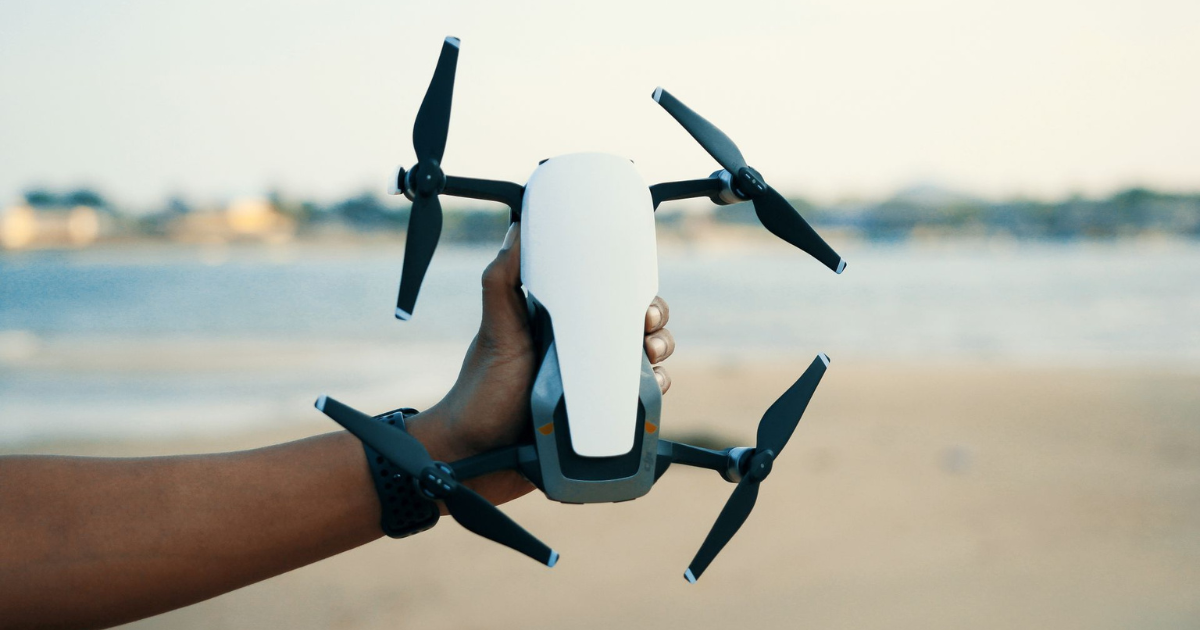 Mão segurando drone com firmeza