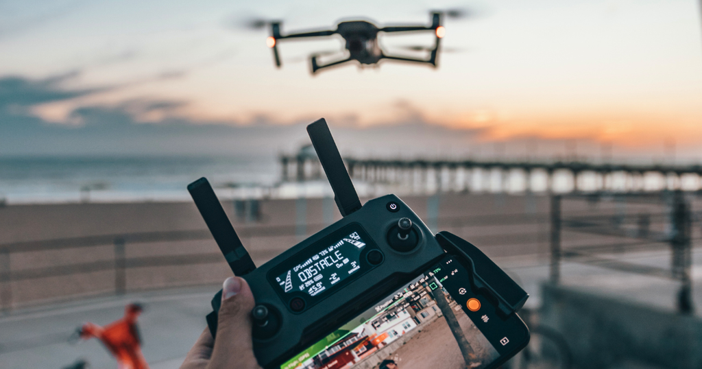 Homem controlando drone apartir do controlado mostrado na imagem